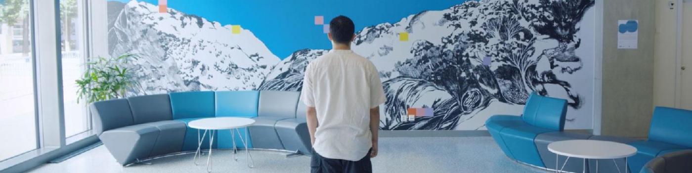artiste devant la fresque du bâtiment Julliard